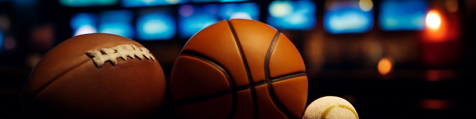 Balón de fútbol americano, balón de baloncesto, pelota de béisbol y disco de hockey, imagen de esta comparativa de casas de apuestas en USA